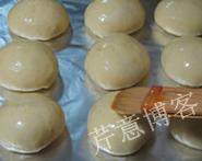 叉烧餐包,发酵至原来的2倍到2.5倍大，轻轻刷上一层全蛋液，还可以撒上几粒芝麻点缀，不撒也可以