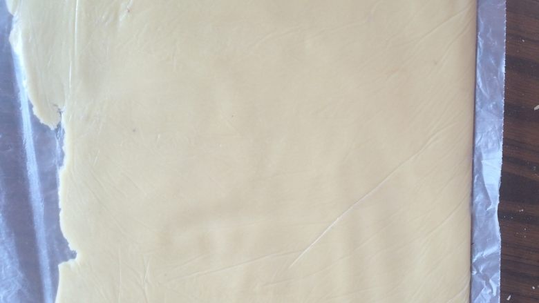 炼乳饼干,装入保鲜袋内,用擀面杖擀成厚度约0.3-0.4cm 的薄片,放冰箱冷冻30分钟。