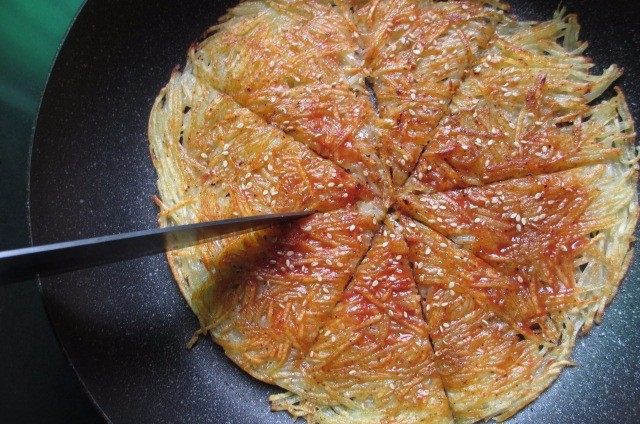 焦脆土豆丝煎饼,用刀切成块,即可食用