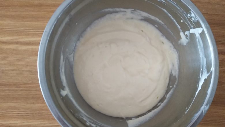 乳酪蛋糕,把混合好的糊全部倒入蛋白,继续画J字,搅拌均匀,蛋糕糊完成后倒入模具,轻震模具,震出大的气泡