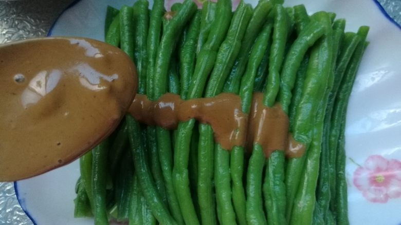 麻酱拌豆角,搅拌好的麻酱浇在豆角上,麻酱豆角就做好了。