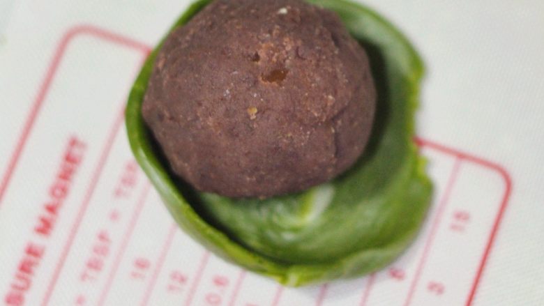 抹茶酥,取一份抹茶面皮擀开,要注意擀成中间厚边缘薄的状态,再把馅包进去。