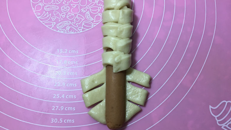 火腿肠辫子面包,然后依次左右的折向火腿,接口处稍压一下。