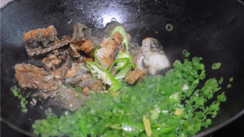 南瓜藤炒干鱼块,将南瓜藤扒到一边,倒入干鱼块