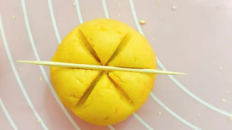 治愈系呆萌小南瓜,
4、 面团用右手在左手的掌心压一个饼放入馅料,包好后揉圆,用牙签在面球上压出三道棱;