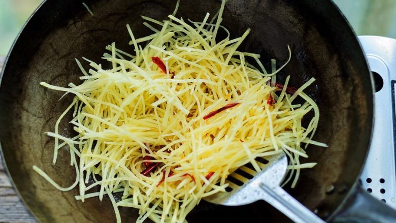 荆芥炒土豆丝,倒进土豆丝，大火烹炒。