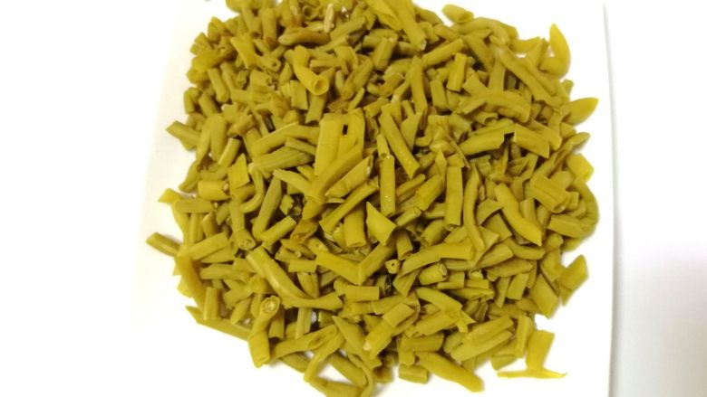 酸豆角炒牛肉末,将炒干水份的酸豆角装盘备用。