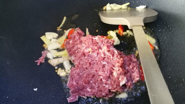 酸豆角炒牛肉末,倒入牛肉末。