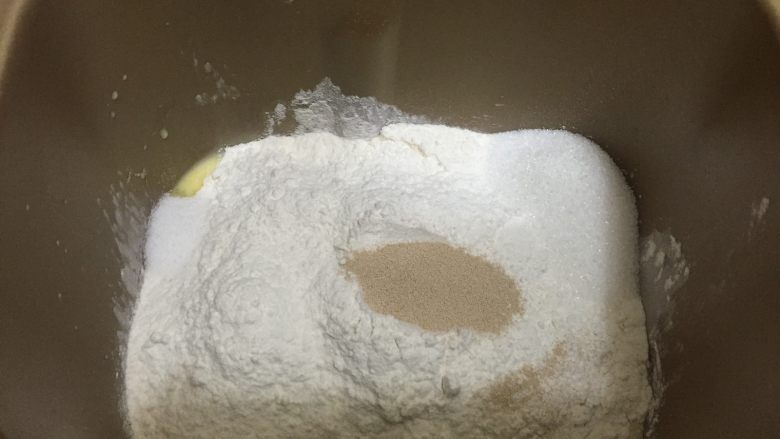 卡路里炸弹 咕咕霍夫重油面包, 将除黄油和酒渍果干以外的所有的材料放入面包桶中,启动和面功能25分钟