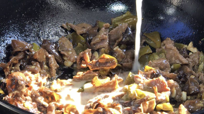酸辣椒炒牛肉,淋入生抽、老抽、淀粉水,翻炒均匀