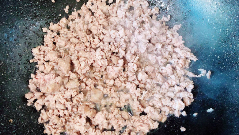 豆腐包子,锅中倒入油,放入梅花肉馅,炒至变色。