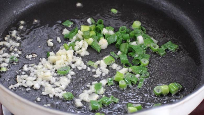 家常拌面,锅中再放适量食用油烧至五成热,将葱花和蒜末小火炒出香味。