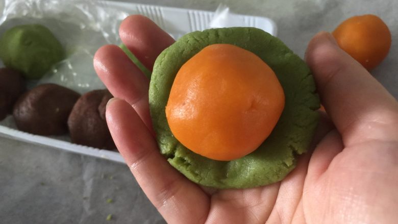 桃山皮月饼,先取抹茶的小团,压扁,放上奶黄馅