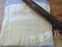 尼可拉可颂,面团快冷冻好的时候,从冰箱中取出冷藏状态的发酵黄油,切成厚片装进保鲜袋,用擀面杖敲打成大厚片
