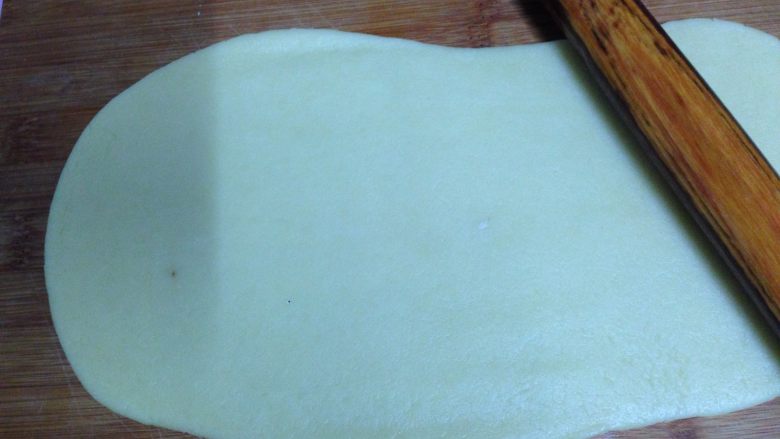 牛奶小饼干,把面团放在案板上,擀成厚约0.3Cm的长方形面片