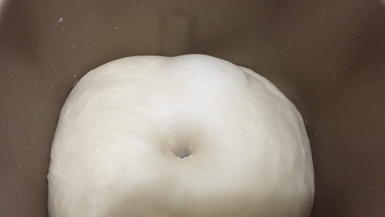 汤种法玉米香肠辫子包,发酵后的面团如图所示,将沾满面粉的手指插入面团中,孔洞不回缩不塌陷即代表发酵完成