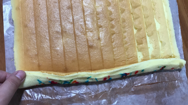 彩色涂鸦蛋糕卷,起始端切掉一公分,趁温热用手压两公分宽的边,弹性很好,非常好压