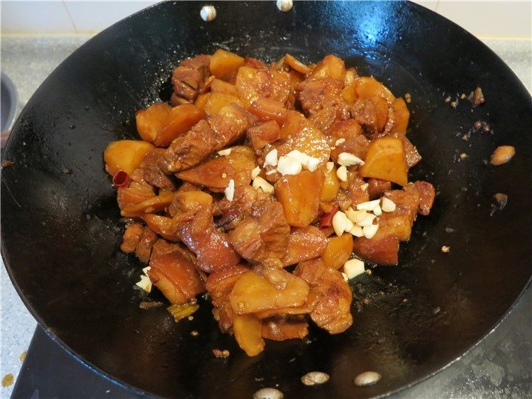 唇齿留香软糯如沙--红烧肉炖土豆,放上切碎的大蒜瓣,翻拌一下可以关火出锅了