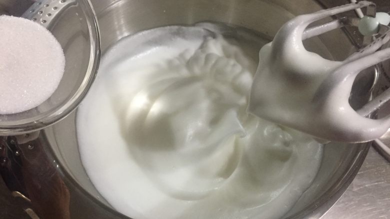 蔓越莓戚风蛋糕,继续中速打发至抬起打蛋头蛋白呈弯勾状态后,加入最后的白砂糖