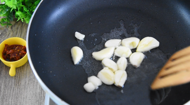 超级快手菜“虎皮豆角”香气扑鼻，超下饭！,油锅倒入少许油，炒香大蒜