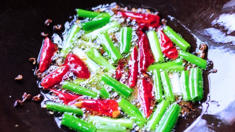 凉拌鱼香茄子,炒锅里倒入油放入小葱段、干辣椒段、<a style='color:red;display:inline-block;' href='/shicai/ 700'>花椒</a>粒大火爆香成香辣油。