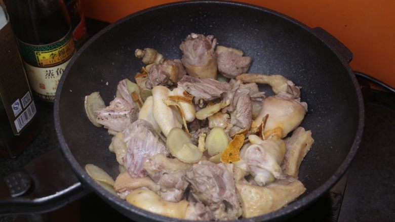 姜焖鸭,油八成热的适合倒入沥干的鸭肉和姜片、陈皮一起翻炒;