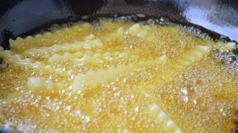 孜然狼牙土豆条,锅内放入油,约7成热时放入土豆条