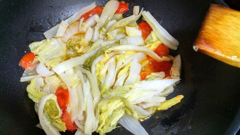 酸菜鱼,把酸菜下入锅里,翻炒一会。