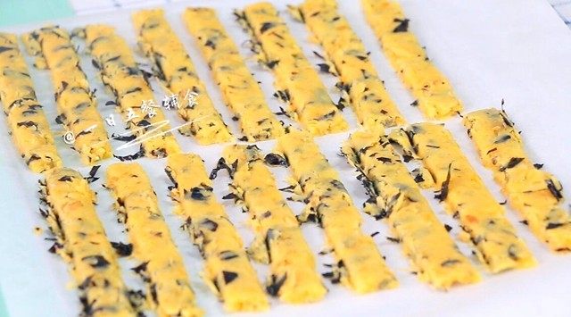海苔肉松条, 把切好的小条排入烤盘。
🌻小贴士:要想边缘比较整齐:①上面提到的将海苔打碎。②将面片放砧板上,用锋利的刀切碎。