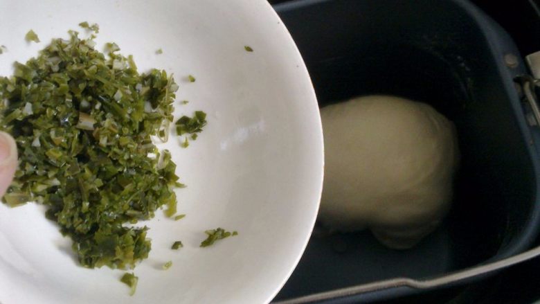 裙带菜素肉汉堡,面团揉成团后,面包机发出蜂鸣声,就可以把切碎的裙带菜加入,面包机会继续揉面,揉面时间结束后,自动进入发酵。