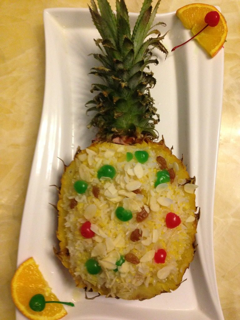 菠萝饭（一）,30分钟后可以尝尝糯米熟透没有，如果硬心就继续蒸一会，待糯米蒸熟后把菠萝拿出锅，用筷子把糯米饭挑叉起来，撒上杏仁片，放几个樱桃或是青红椒点缀即可！