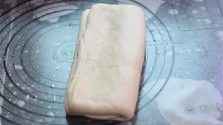 黑白芝麻可颂,三折,将面团顺折边方向擀长后进行第二次三折