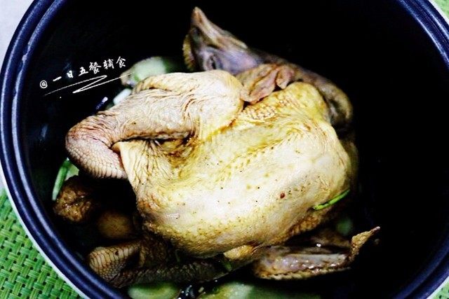盐焗手撕鸡,把腌制好的三黄鸡放入电饭煲,先脚那面朝天。盖盖。接通电源按下煮饭档。