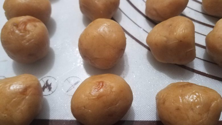 桃山皮月饼,芒果香橙馅也取出来,同样的方法揉搓均匀,馅料颜色会微微变浅,搓成球状,表面略油。