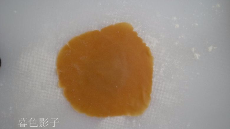 广式蛋黄月饼,取一个面皮,面案上撒点干粉,擀压成面皮