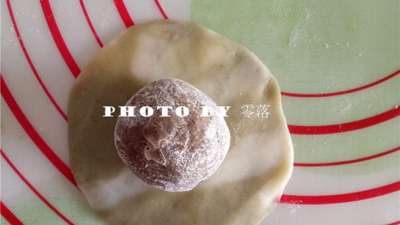 抹茶冰皮月饼,取一份双色面团,按扁,包入枣泥馅;