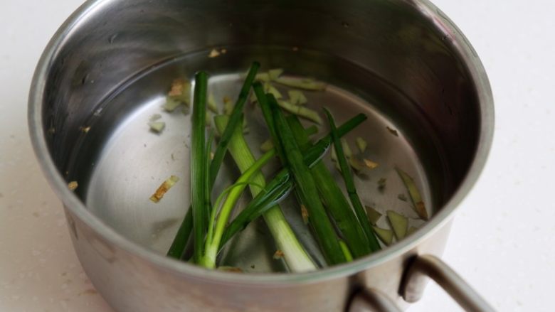 蛤蜊蒸水蛋,将小葱和生姜放入煮锅,加水大约350克和盐1克。