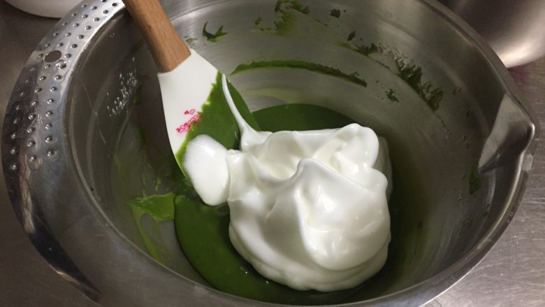浓郁抹茶蛋糕卷,取三分之一的蛋白霜放入蛋黄糊中,翻拌均匀