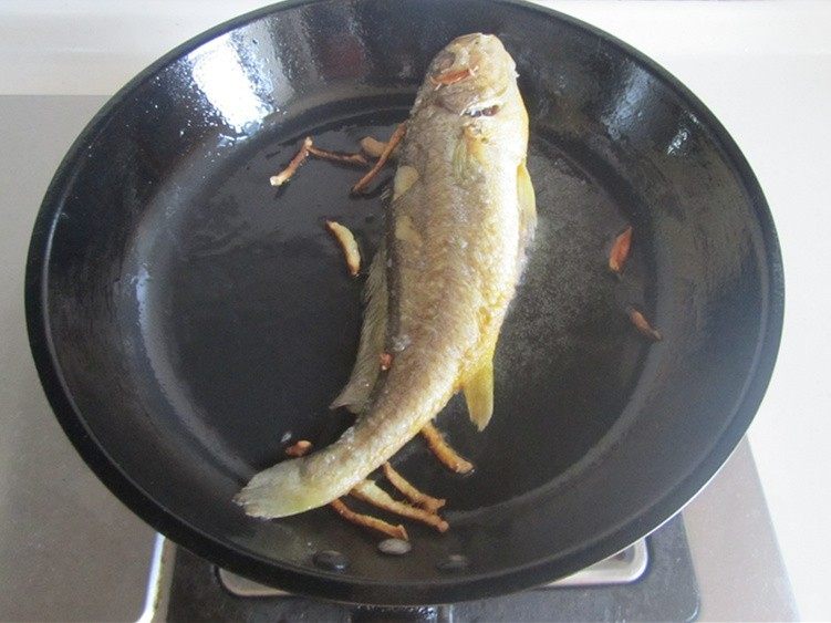 黄鱼焖豆腐,轻轻晃动下锅, 鱼能跟着动后再煎会儿翻个面将另一面也煎至金黄;