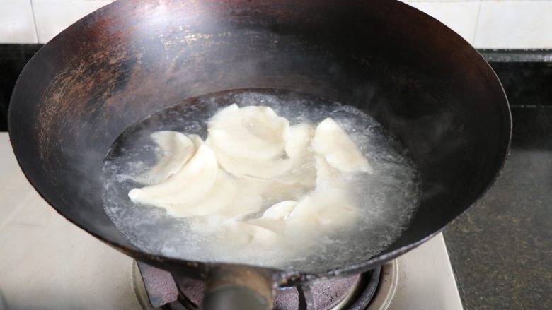 酸青瓜羊肉水饺,锅中水烧开后放入饺子,水煮沸饺子浮起后加入适量冷水,烧开后再加入冷水,加3次冷水后饺子浮起即可捞出;