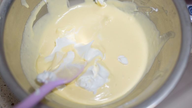 懒人食谱破壁机棉花轻乳酪,先加入1/3的蛋白翻拌,再倒入全部蛋白翻拌均匀,要兜底翻拌