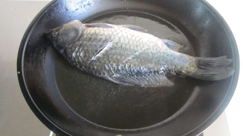 鲫鱼豆腐汤,热锅凉油, 将鲫鱼表面上的水分吸干后放入锅中煎;