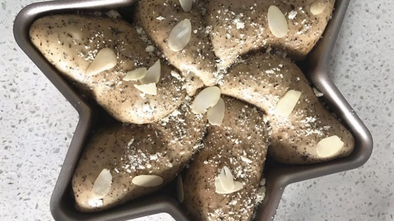 伯爵红茶奶酥面包, 表面撒酥粒,杏仁片,放入预热好的烤箱,中下层,上下火180度25分钟左右。上色及时加盖锡纸。