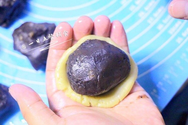 蛋黄豆沙月饼 ,取一份饼皮在手心按扁,包入馅料。