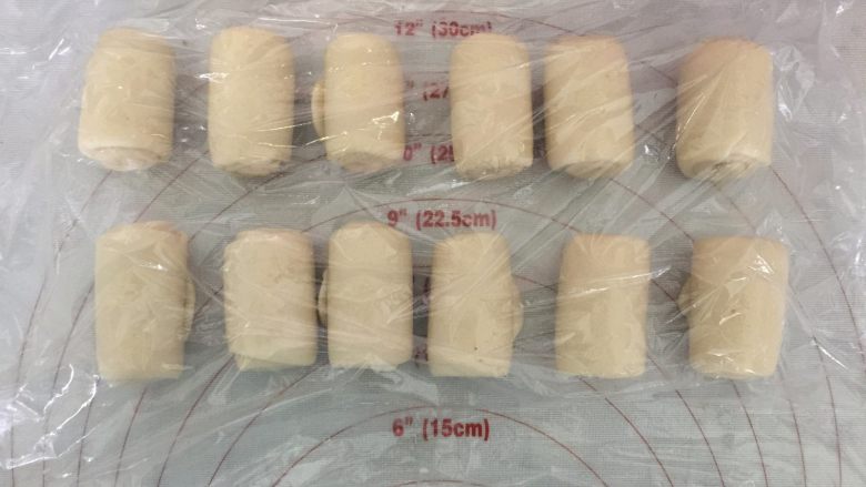 板栗酥饼,松驰之后,取一份,收口向上,用擀面杖擀长后再次卷起来,盖上保鲜膜,松驰15分钟