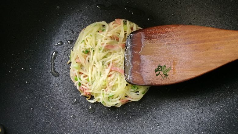 土豆丝饼,锅中放油加热,放入土豆丝,用铲子整理一下,成圆饼状。