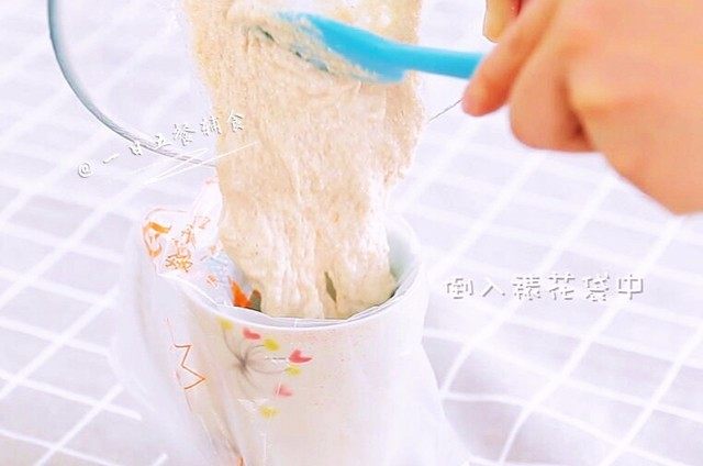 番茄手挤面,面粉加入水中,搅拌成可流淌的糊状。裱花袋套在杯子上,面粉糊倒入,裱花袋剪一个口。口的大小决定了面的粗细。