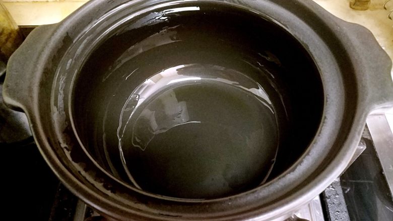 香肠砂锅煲仔饭,往砂锅里倒入一点植物油,用小刷子把砂锅的内部都刷上植物油。