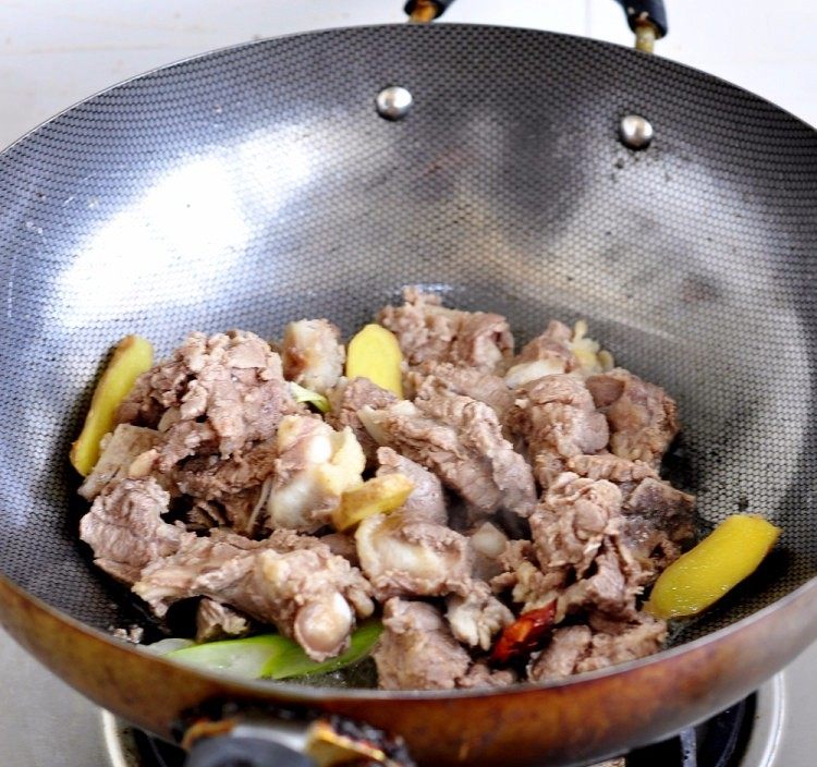 土豆炖牛仔骨,加入牛仔骨,慢炒出水分,肉炒至微黄即可。