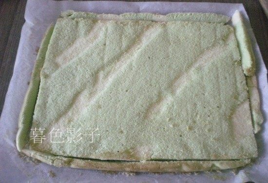彩条蛋糕卷,烤好的蛋糕及时拿出来,倒扣在晾网上、揭去油纸、在蛋糕表面盖一张油纸避免干燥、切去四边不整齐的边缘